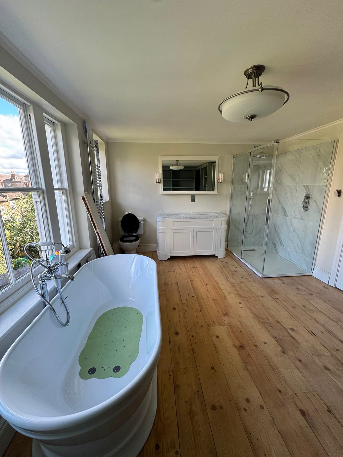 Renovated bedroom and bathroom with freestanding bath and fitted dressing-room storage