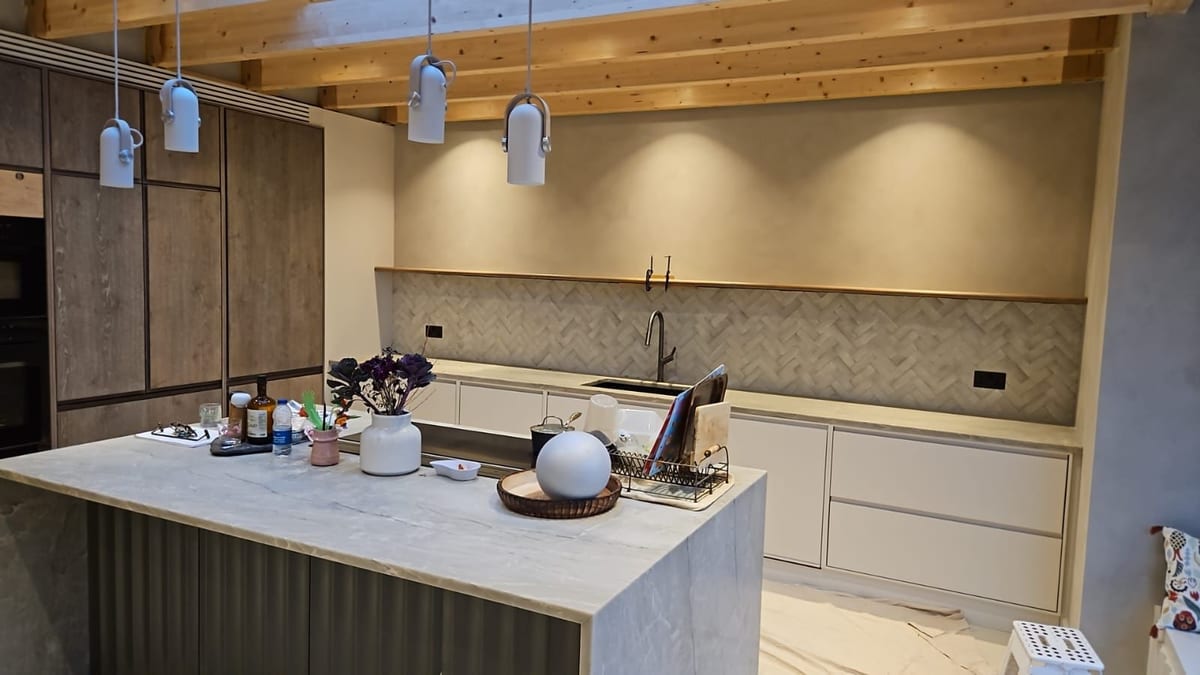 Open-plan kitchen renovation with bespoke cabinetry, island lighting and tiled splashback